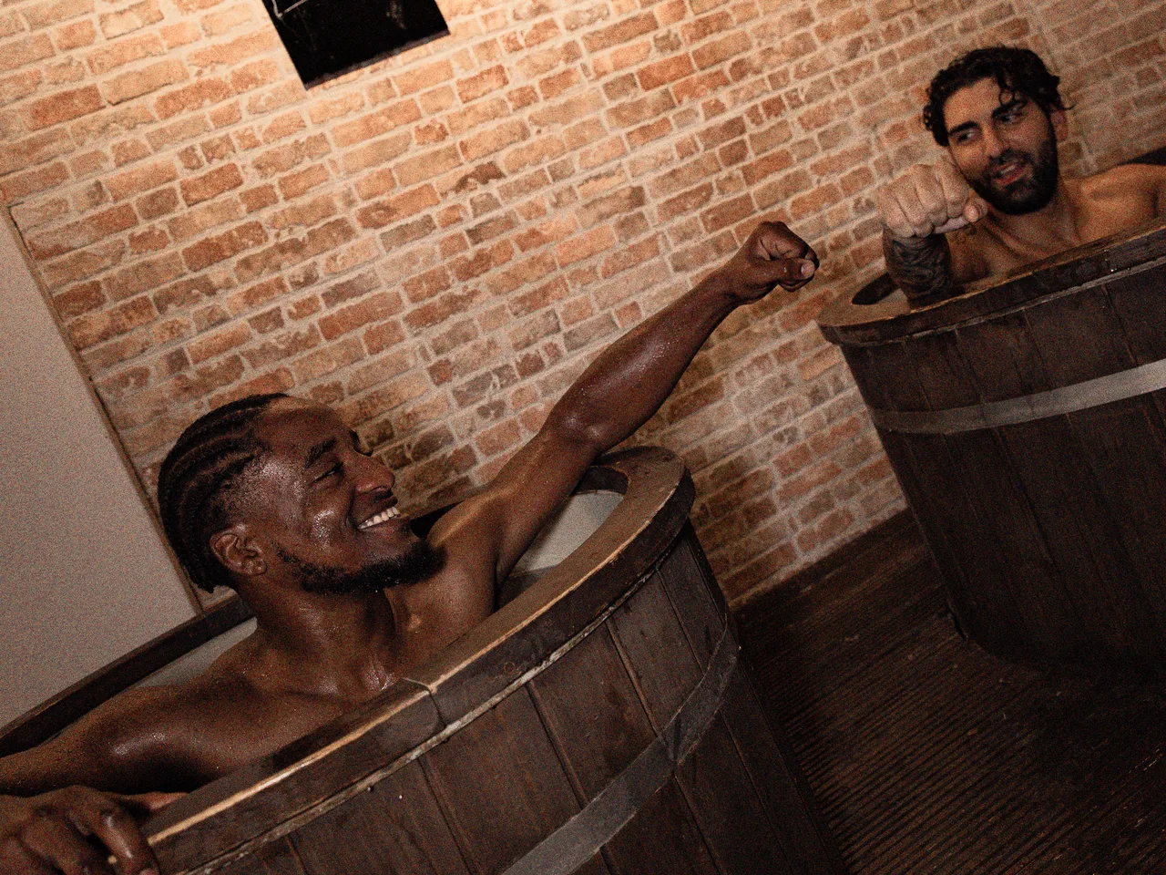 Two members fist-bumping between cold plunges at Pulse Club Fulham
