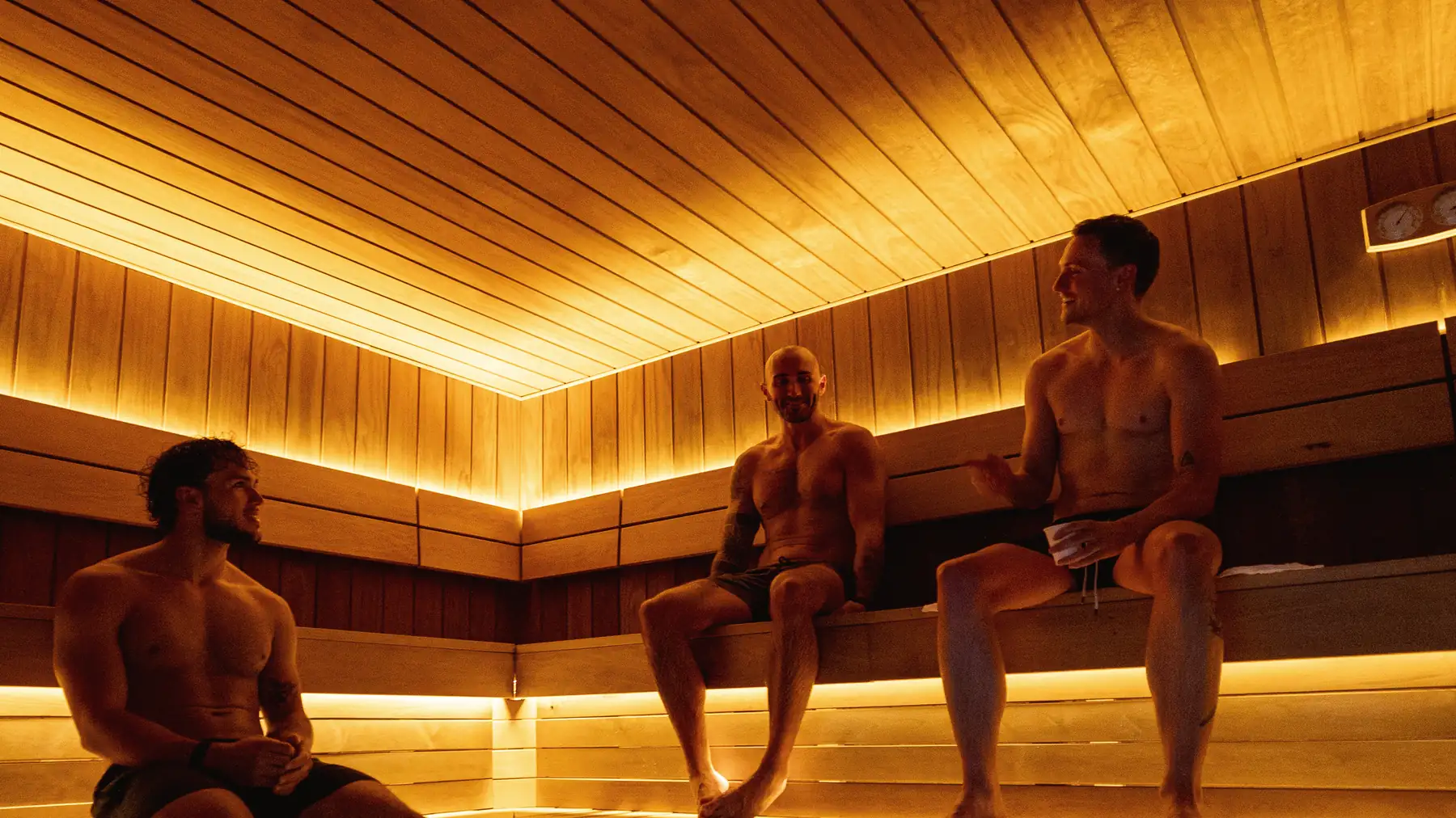 Three members from a Putney run club chatting on the sauna benches